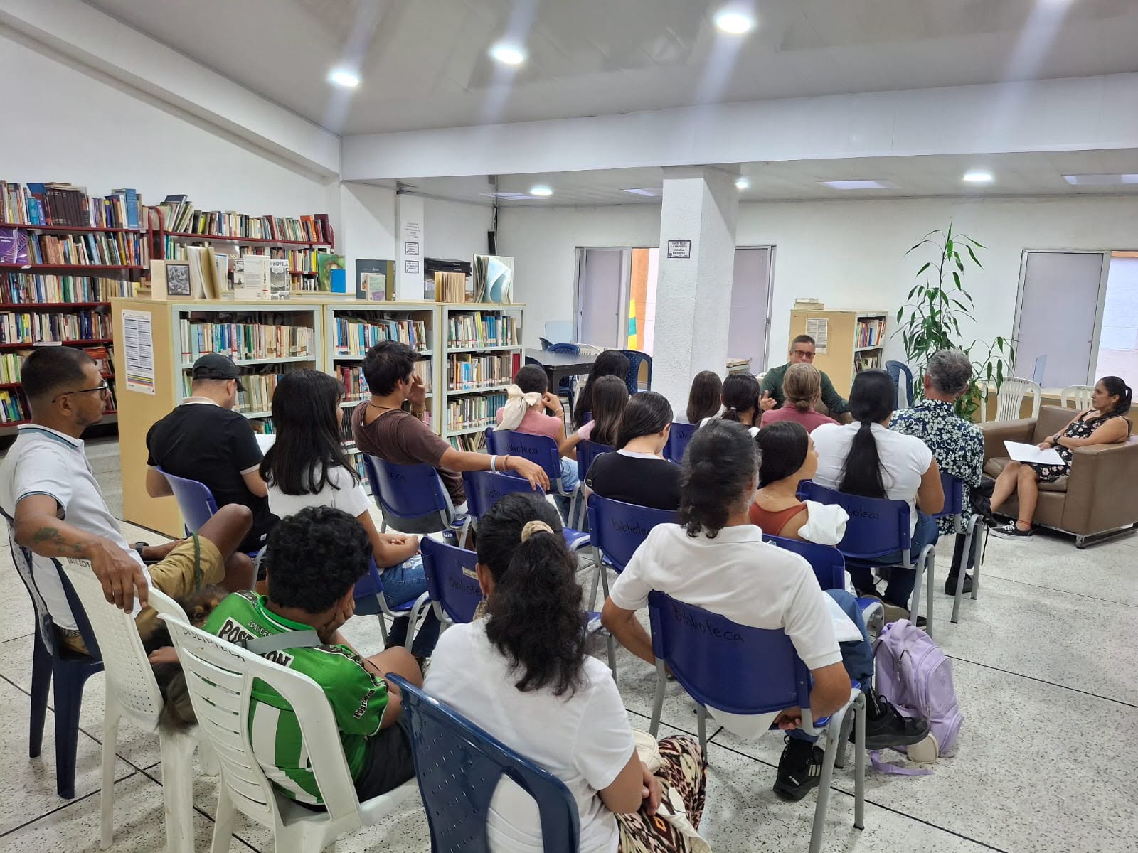 Carlos Sánchez Ortiz conversando con una audiencia en una biblioteca.