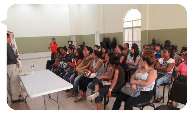 Osmar Mejía Mejía motivando a un grupo de mujeres en un salón de conferencias.